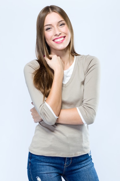 Bella giovane donna che guarda l&#39;obbiettivo su sfondo bianco.