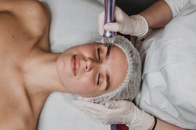 Bella giovane donna che ha un trattamento cosmetico