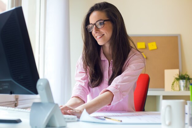 Bella giovane donna che lavora nel suo ufficio.