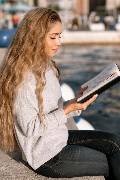 Bella giovane donna che legge un libro