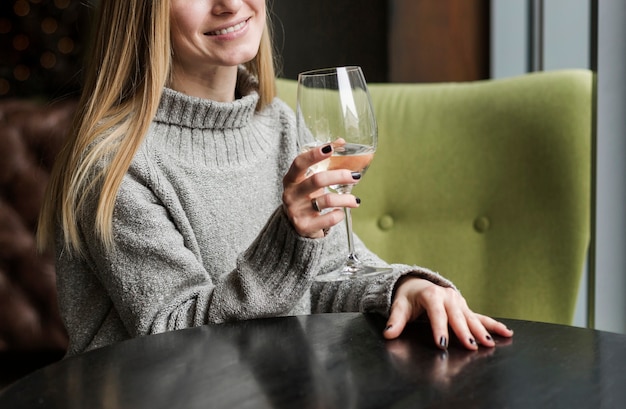 Bella giovane donna che mangia un bicchiere di vino