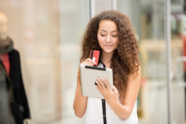 Bella giovane donna che paga con carta di credito per lo shopping