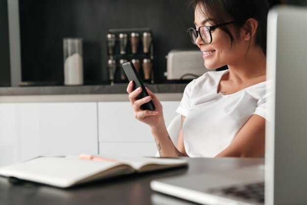 Bella giovane donna che per mezzo del telefono cellulare.