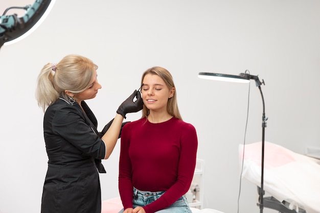 Bella giovane donna che si sottopone a un trattamento di microblading