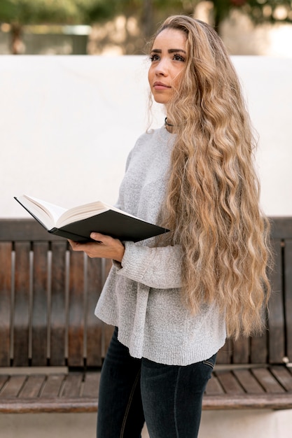 Bella giovane donna che tiene un libro