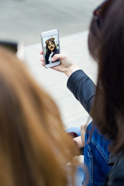 Bella giovane donna che utilizza il suo cellulare in strada.