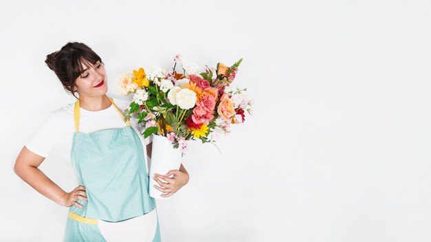 Bella giovane donna con fiori su sfondo bianco