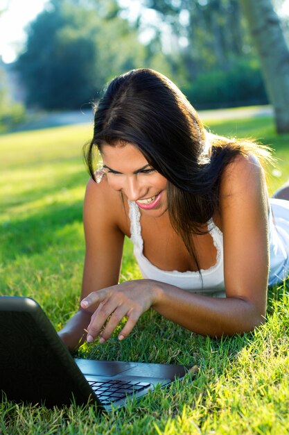 Bella giovane donna con il computer portatile a casa.