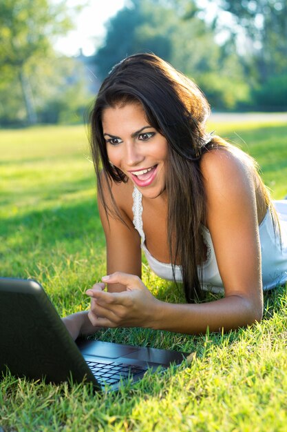 Bella giovane donna con il computer portatile a casa.