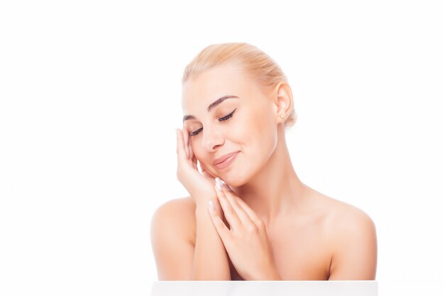 Bella giovane donna con la pelle pulita fresca tocca il proprio viso. Trattamento facciale . Cosmetologia, bellezza e spa.