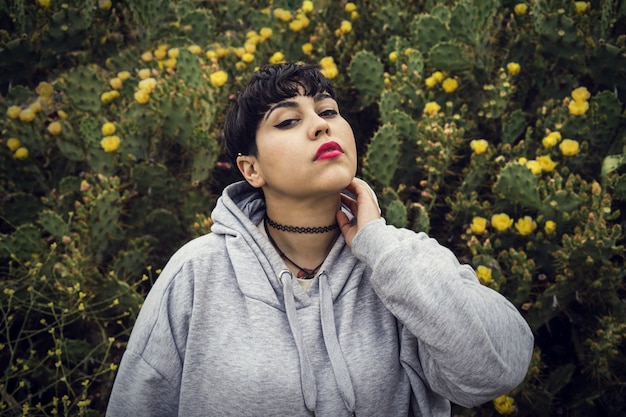 Bella giovane donna con rossetto rosa e cactus