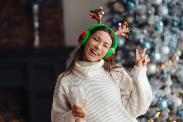 Bella giovane donna con un bicchiere di champagne a casa