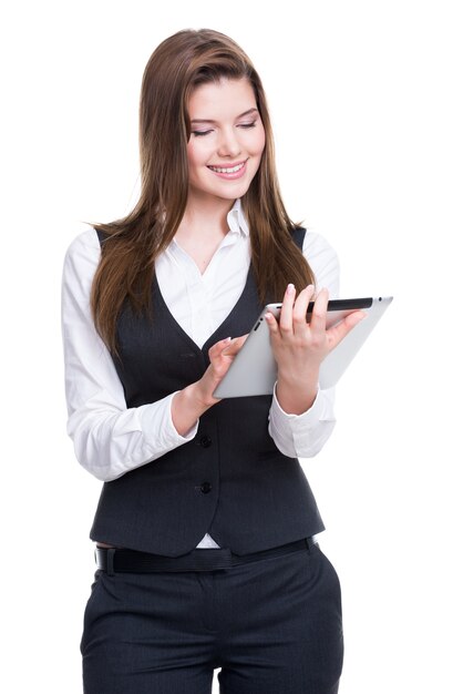 Bella giovane donna d'affari sorridente in un abito grigio utilizzando tablet su sfondo bianco.