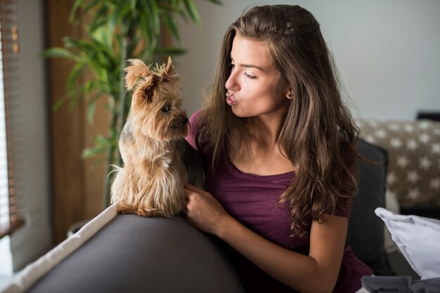 Bella giovane donna felice che posa con il suo piccolo cane