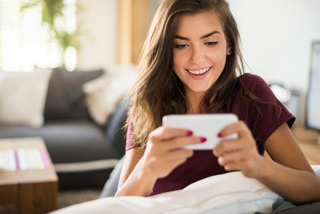 Bella giovane donna felice con lo smartphone nell'orientamento orizzontale