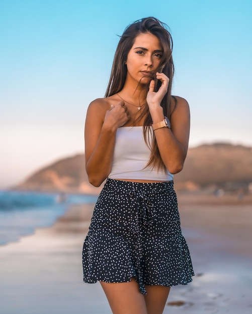 Bella giovane donna in abbigliamento estivo casual in posa mentre si cammina sulla spiaggia di Zarautz in Spagna