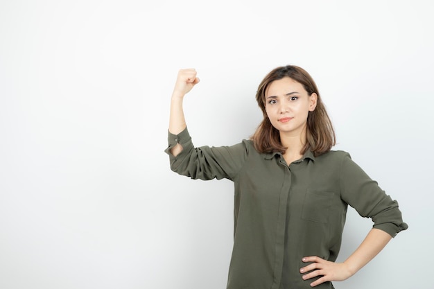 Bella giovane donna in abito casual che mostra i suoi muscoli. Foto di alta qualità