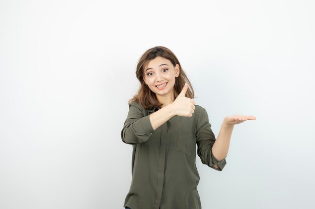 Bella giovane donna in abito casual che mostra i suoi palmi aperti. Foto di alta qualità