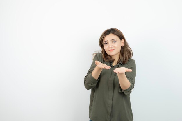 Bella giovane donna in abito casual che mostra i suoi palmi aperti. Foto di alta qualità