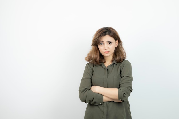 Bella giovane donna in abito casual in piedi con le braccia incrociate. Foto di alta qualità