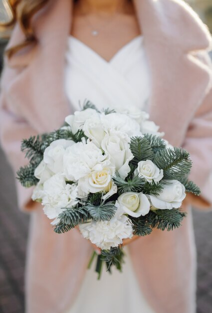 Bella giovane donna in abito da sposa in posa sulla strada in città