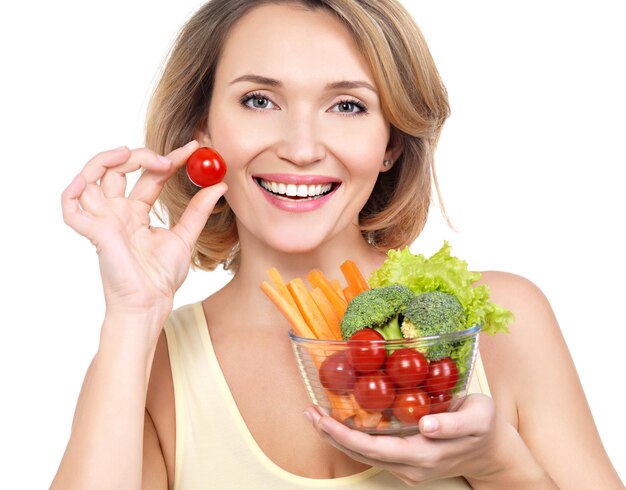 Bella giovane donna in buona salute con un piatto di verdure - isolato su bianco.