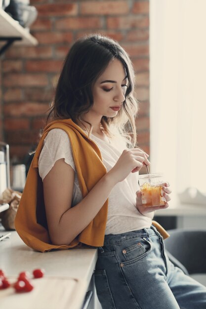 Bella giovane donna in cucina