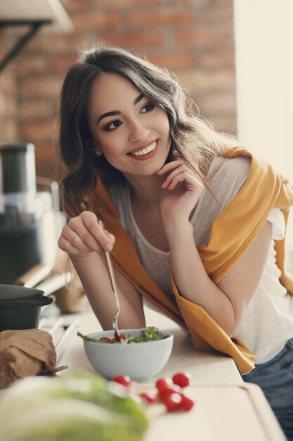 Bella giovane donna in cucina