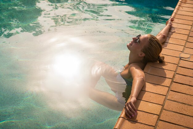 Bella giovane donna in piscina