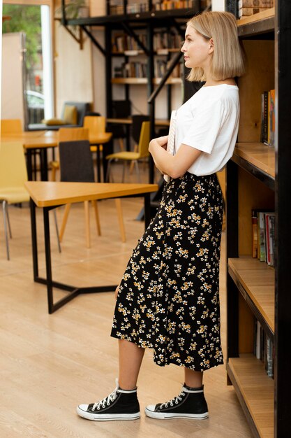 Bella giovane donna in posa in biblioteca