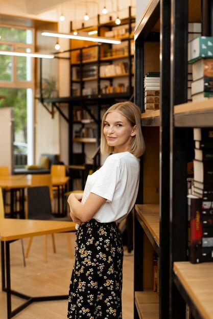 Bella giovane donna in posa in biblioteca