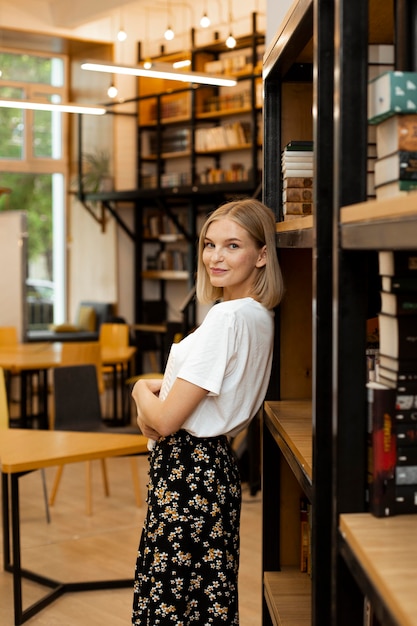 Bella giovane donna in posa in biblioteca