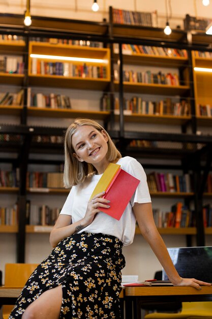 Bella giovane donna in posa in biblioteca