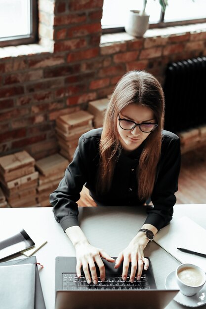 Bella giovane donna in ufficio a casa. Lavorare da casa. Concetto di telelavoro