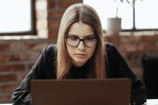 Bella giovane donna in ufficio a casa. Lavorare da casa. Concetto di telelavoro