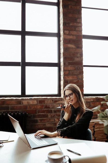 Bella giovane donna in ufficio a casa. Lavorare da casa. Concetto di telelavoro