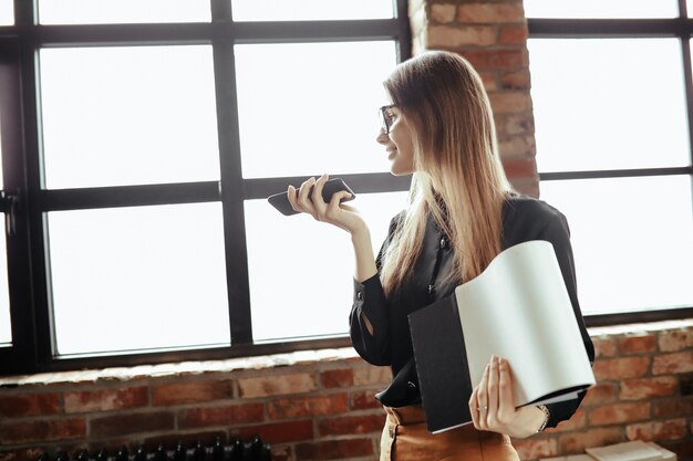 Bella giovane donna in ufficio a casa. Lavorare da casa. Concetto di telelavoro