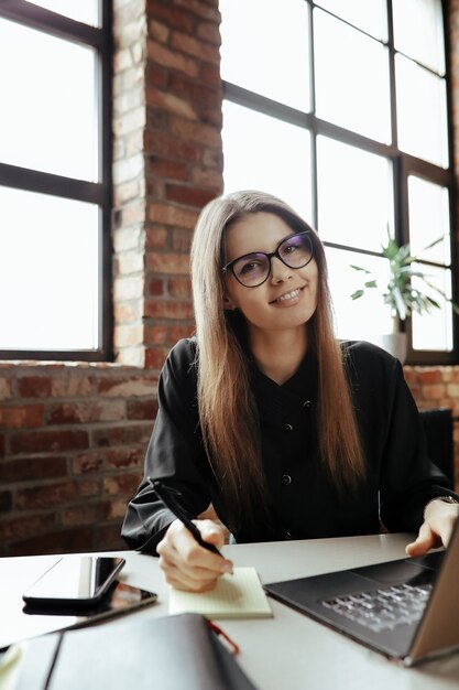 Bella giovane donna in ufficio a casa. Lavorare da casa. Concetto di telelavoro