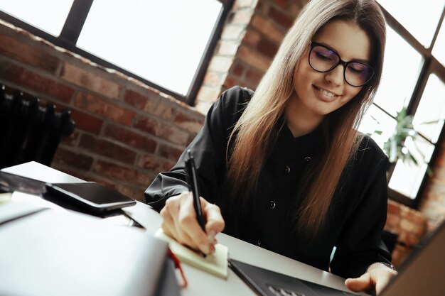 Bella giovane donna in ufficio a casa. Lavorare da casa. Concetto di telelavoro