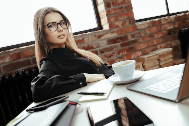 Bella giovane donna in ufficio a casa. Lavorare da casa. Concetto di telelavoro