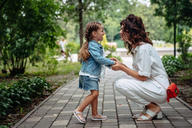 Bella giovane mamma e figlia in una giornata di sole al parco, famiglia felice