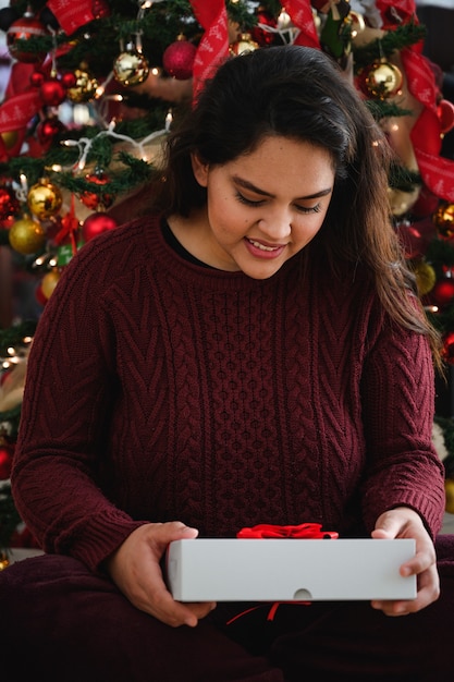 bella giovane signora che tiene un regalo di Natale