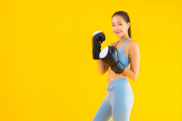 Bella giovane sportwear asiatico di usura della donna del ritratto su giallo