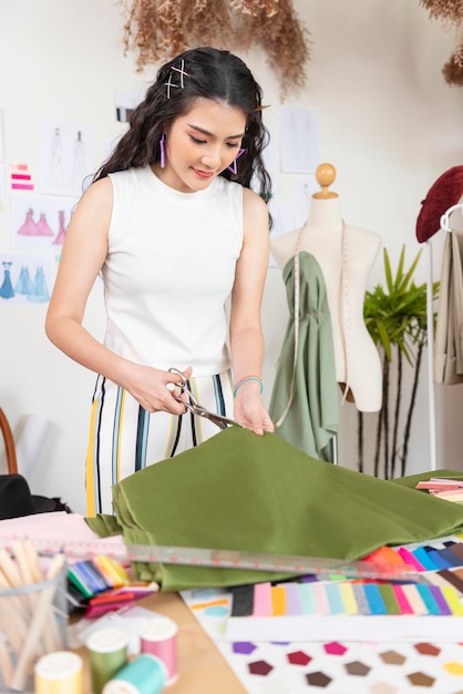 bella giovane stilista femminile che lavora sartoria nuovo vestito fatto a mano in officina