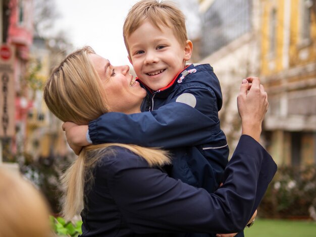 Bella madre che tiene il suo bambino all'aperto