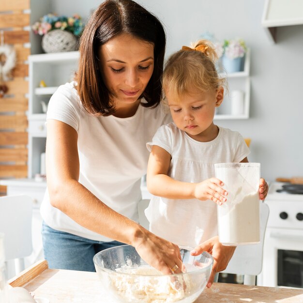 Bella madre e figlia adorabile che cucinano insieme