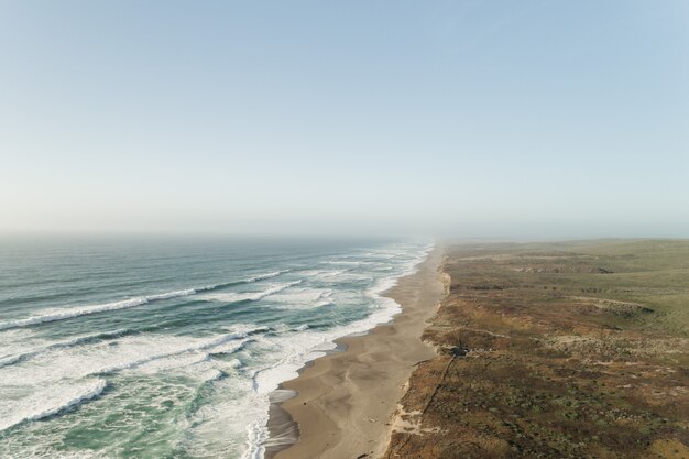 Bella panoramica dell'oceano vicino ad un deserto sotto un chiaro cielo blu