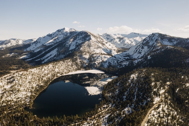 Bella panoramica delle montagne ricoperte di neve circondata da alberi e un lago