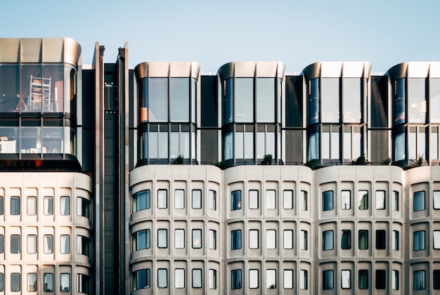 Bella panoramica di moderna architettura bianca con grandi finestre di vetro sotto un cielo blu chiaro