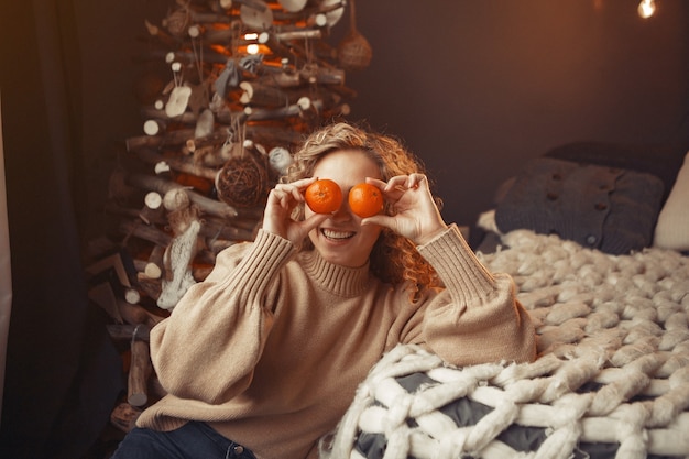 Bella ragazza a casa vicino all'albero di Natale